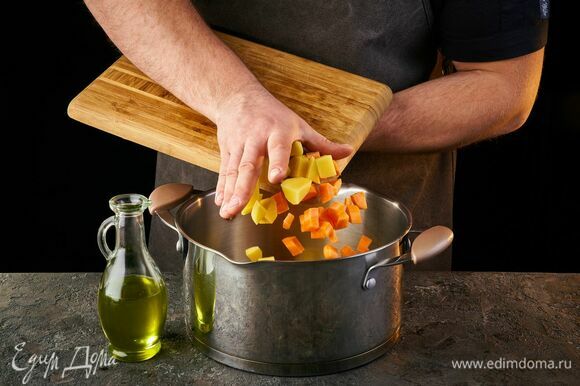 Картофель, морковь и лук нарежьте кубиками, залейте холодной водой и поджарьте на дне кастрюли.