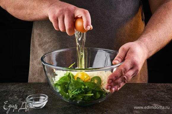 Шпинат промойте и мелко порубите. Выложите все в миску, добавьте яйцо, соль по вкусу, перемешайте.