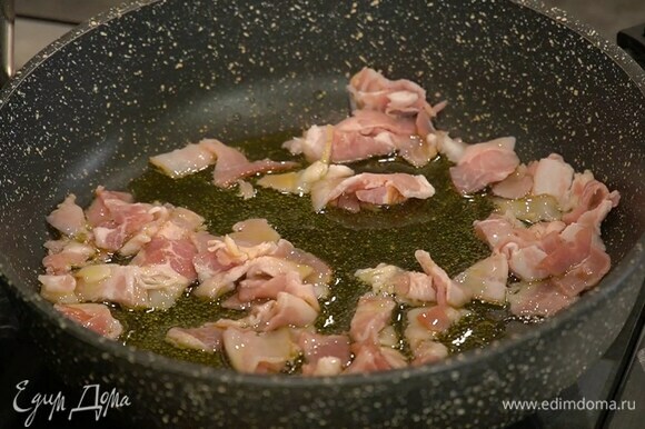 Разогреть в сковороде оливковое масло и обжарить грудинку. Добавить лук и чеснок.