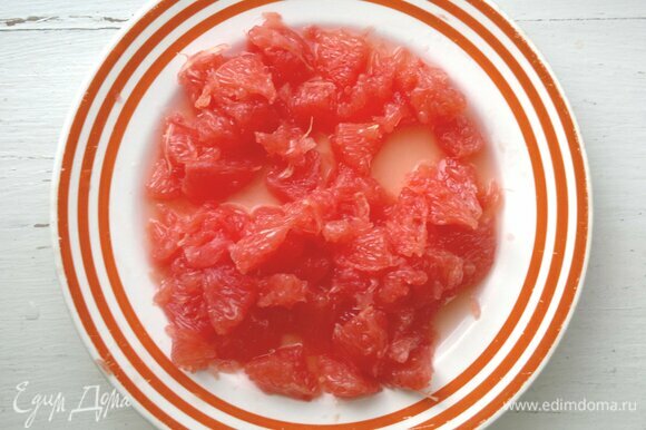 Грейпфрут очистить от кожуры и пленок. Чистить лучше всего над тарелкой, чтобы сохранить сок для заправки. Разрезать грейпфрут на небольшие кусочки.