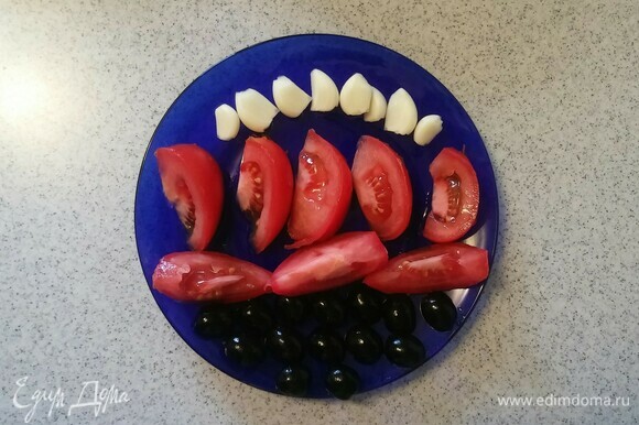 Зубчики чеснока и маслины нужно разрезать пополам, а помидор — на 8 равных частей.