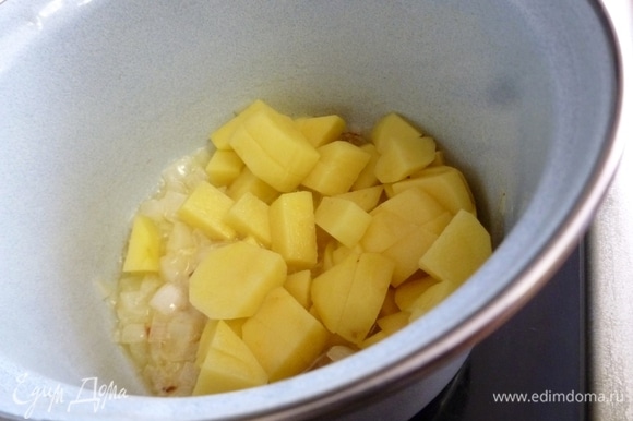 Картофель нарезать небольшими кубиками и отправить к луку. Обжаривать все вместе до легкого румянца.
