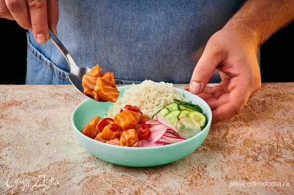 Выложите в глубокую тарелку Luminarc рис, кубики лосося, измельченные огурцы, редис. Посыпьте рыбу кунжутом и рубленым зеленым луком.