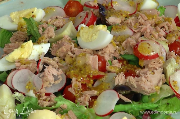 Салатный микс и все подготовленные овощи выложить на большую тарелку, сверху разложить маслины, кусочки тунца и яйца, полить все заправкой.