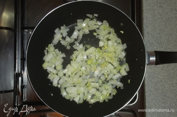 Сковородку смазать оливковым маслом и обжарить на ней нарезанный репчатый лук до мягкости вместе с измельченными зубчиками чеснока (на среднем огне маленькой конфорки плиты).