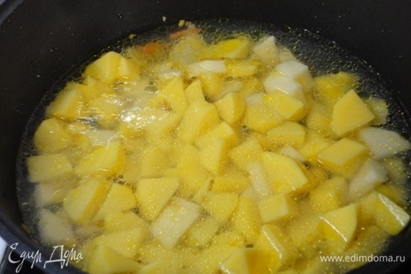 Картофель нарежьте средними кубиками и выложите в сотейник к овощам, залейте горячей водой, добавьте лавровый лист, посолите, доведите до кипения.