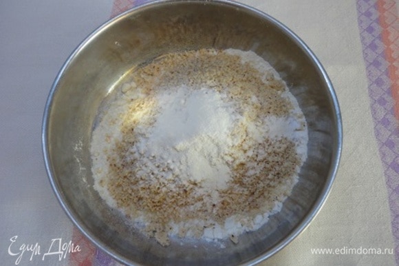 Муку соединить с мелко молотым миндалем и разрыхлителем. Шоколад с маслом растопить на водяной бане. Включить духовку на 180°C.