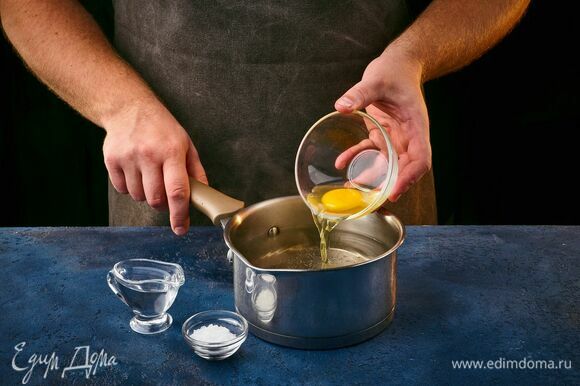 Сварите яйцо пашот. Сотейник наполните водой, добавьте уксус и соль, перемешайте. Яйцо заранее аккуратно разбейте в маленькую миску. Воду доведите до кипения, сделайте средний огонь. При помощи венчика закрутите воронку и быстро, но осторожно опустите яйцо в центр этой воронки. Варите 2 минуты.