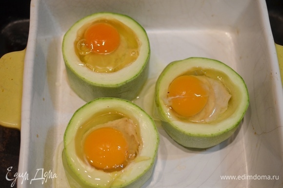 Выложите колечки в жаропрочную форму и аккуратно вбейте яйца. Запекайте в раогретой до 180°C духовке до желаемой консистенции яйца, но не менее 20 минут, чтобы фарш успел дойти до готовности.
