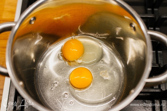 В сотейник или кастрюлю с толстым дном разбить яйца.