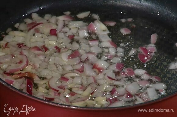 Приготовить соус: половинку красной луковицы и зубчик чеснока почистить и тонко нарезать, затем разогреть в сковороде оливковое масло и обжарить лук с чесноком.