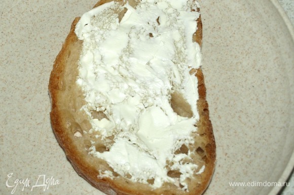 Горячий хлеб смазать творожным соленым сыром. Этот шаг можно пропустить.