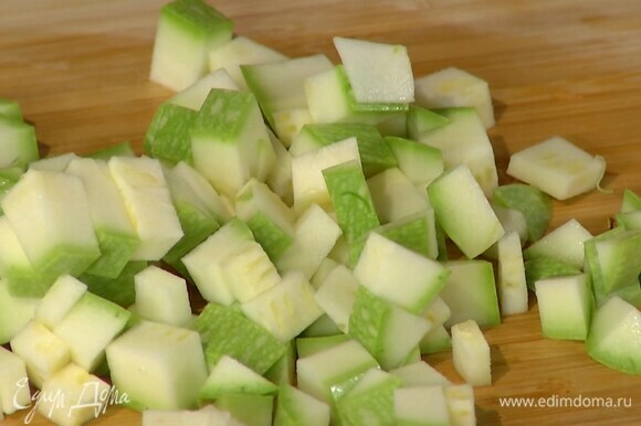 Кабачок порезать маленькими кубиками, добавить в сковороду с овощами, все посолить и обжарить.