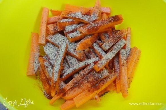 Разогрейте духовку до 220°C. Противень застелите пекарской бумагой или ковриком. Морковь очистите и нарежьте брусочками размером примерно 10х1,5х1,5 см. Смешайте чесночный порошок, паприку, черный перец и немного соли. Полейте морковные брусочки оливковым маслом, перемешайте, посыпьте смесью специй, снова перемешайте.