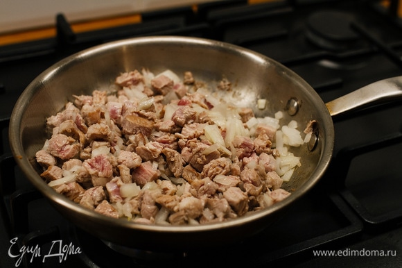 Овощи, лук и мясо нарезать кубиками. На сковороде раскалить растительное масло, выложить мясо и лук. Обжаривать 2–3 минуты.