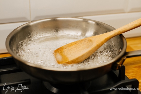 В сковороде растопить сахар с водой и постоянно помешивать, пока сахар не приобретет золотисто-коричневый оттенок.