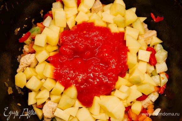 Добавить нарезанный кубиками картофель. Помидор залить кипятком, очистить от кожицы и пробить блендером, добавить к овощам в казан.