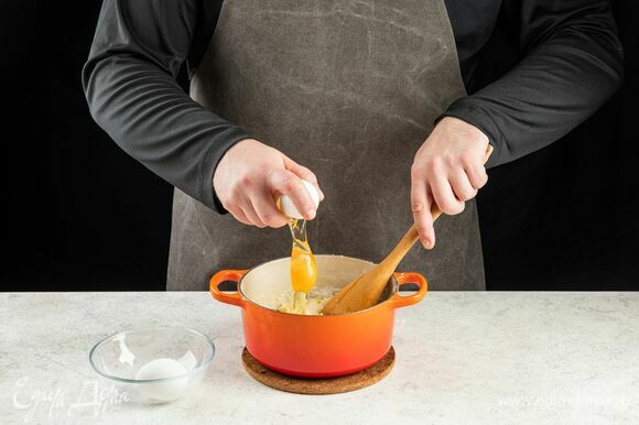 Снимите сотейник с огня и медленно перемешивайте тесто около 3 минут, пока оно не остынет. Добавьте яйца по одному, перемешайте.