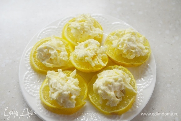 На кружки лимона выложите острый сыр.