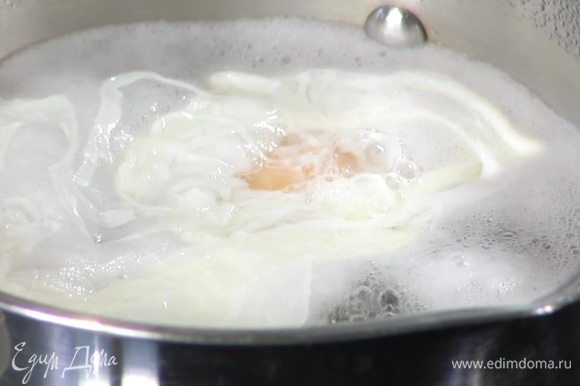 Приготовить яйцо пашот: в небольшой кастрюле вскипятить 500 мл воды, добавить уксус, с помощью венчика сделать маленький водоворот и в центр воронки вылить яйцо. Убавить огонь и варить 2–3 минуты, затем шумовкой выложить на бумажное полотенце.