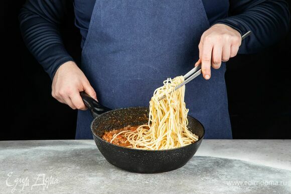 Отварите спагетти до готовности. Слейте воду. Добавьте пасту к соусу болоньезе, перемешайте.
