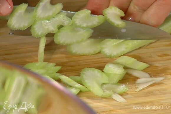 Сельдерей тонко нарезать поперек и добавить в салат.