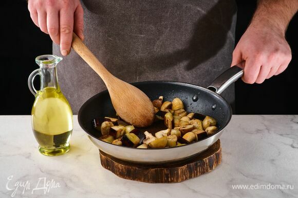 На сковороде в оливковом масле обжарьте шампиньоны. Готовьте на небольшом огне, помешивая, около 10 минут. При необходимости влейте немного воды. Добавьте нарезанные баклажаны и обжаривайте около 3 минут.