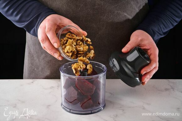 Выложите в чашу блендера отварную свеклу и грецкие орехи. Измельчите.