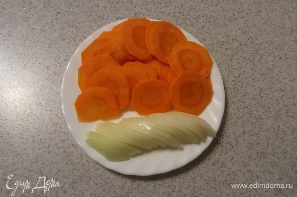 Пока куриные сердечки маринуются, нужно подготовить овощи для луково-морковной подложки. Для этого репчатый лук нарезать дольками, а морковь — тонкими кружочками (толщина кружочка — 1 мм).