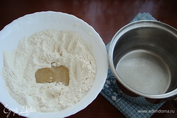 В миску просейте муку, влейте растительное масло, горячую воду с солью и сахаром. После этого добавьте водку и замесите тесто.