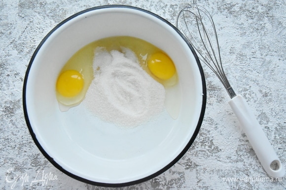 Соединить в миске яйца и сахар и слегка взбить смесь венчиком.