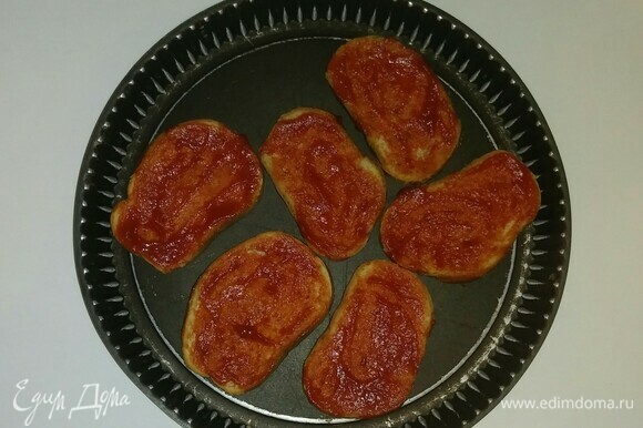 На противень (не смазывая его маслом) выложить тосты и смазать их протертыми помидорами.