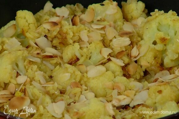 В готовый рис, удалив лавровый лист, добавить цветную капусту с луком, все перемешать и посыпать миндальными лепестками.