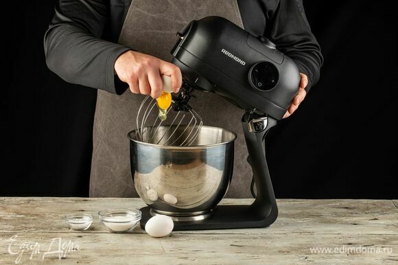 На кухонную машину REDMOND RKM-4021 установите насадку венчик. В чашу выложите яйца, сахар и щепотку соли. Слегка взбейте.