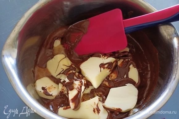 Растопленному шоколаду дать немного остыть, затем добавить мягкое сливочное масло и перемешать до полного его растворения.