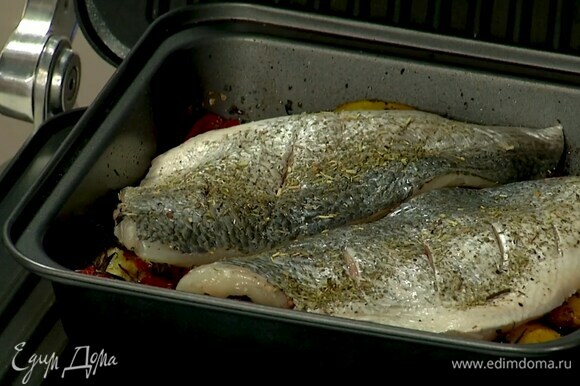 Посыпать дораду специями для рыбы со всех сторон, посолить, и выложить в форму на овощи, затянуть сверху фольгой и запекать в гриле еще 5‒7 минут.