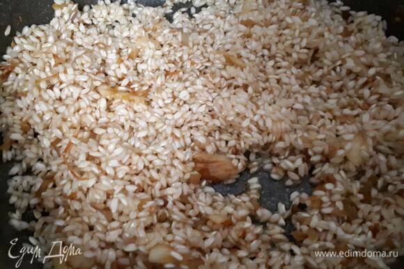 Всыпьте рис и прожарьте 1–2 минуты, постоянно помешивая. Затем влейте ром и дайте ему выпариться.