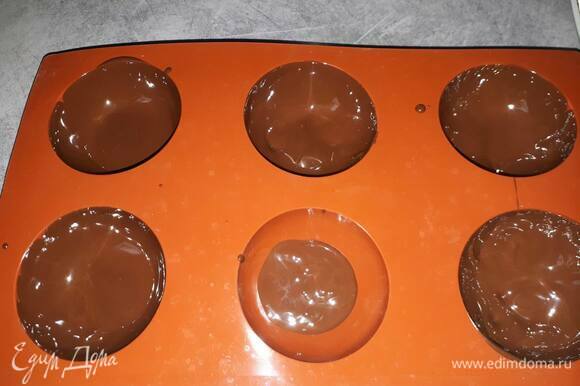 Разлейте шоколад по силиконовым формам 6 см в диаметре примерно до половины и размажьте шоколад по стенкам.
