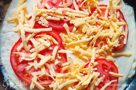 Выложить помидоры, посыпать сыром, накрыть тортильей и повторить слой с колбасой. Накрыть последней тортильей и сверху вылить взбитое одно яйцо.