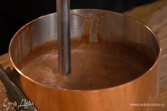 Снять кастрюлю с огня и погружным блендером взбить молоко с шоколадом в однородную массу.