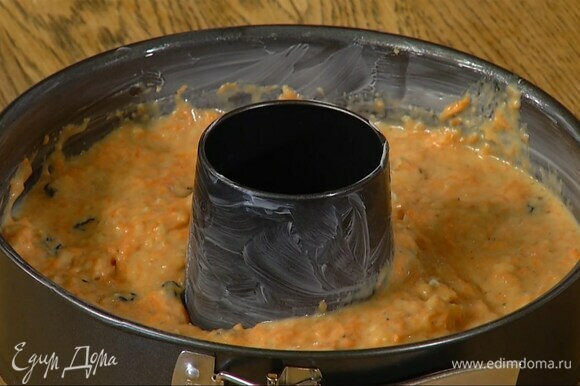 Молоко влить в тесто, все перемешать и выложить в круглую форму с выемкой, смазанную оставшимся сливочным маслом.