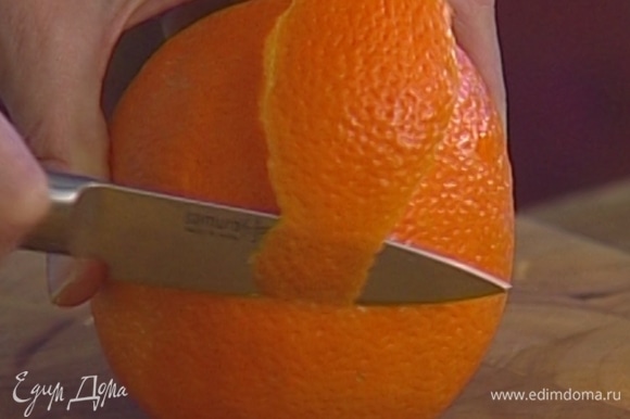 С апельсина тонкими полосками срезать цедру.