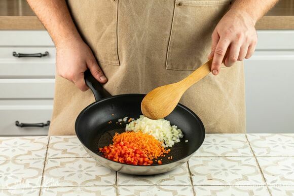 Нарежьте лук, перец и морковь мелким кубиком и обжарьте на оливковом масле в течение 5 минут.