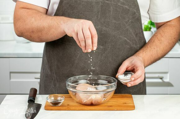 Натрите куриную грудку крупной солью и молотым перцем со всех сторон. Оставьте на 10–15 минут.