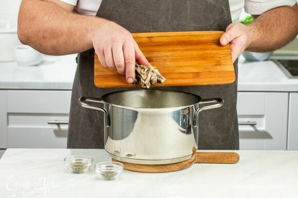 К мягкому карамелизированному луку добавьте анчоусы, тимьян и орегано. Продолжайте томить смесь в течение 15 минут.