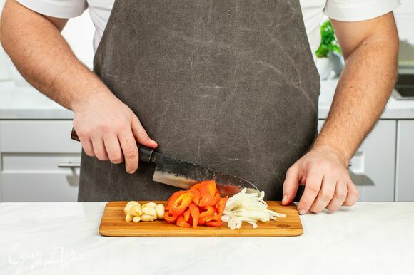 Достаньте овощи из духовки, дайте им остыть и очистите. Нарежьте перец на брусочки. Лук порубите тонкой соломкой.