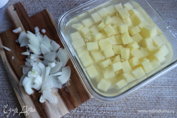 Почистить картофель, нарезать на кубики среднего размера, нарезать оставшийся лук.