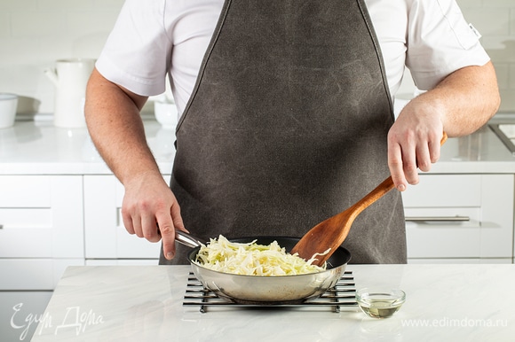 Для начинки нашинкуйте белокочанную капусту и потушите ее в глубокой сковороде под крышкой на маленьком огне. Предварительно смажьте сковороду 3 ст. л. растительного масла.