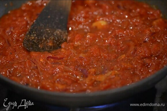 Приготовить соус: разогреть в сковороде 1–2 ст. ложки оливкового масла и обжарить лук и чеснок, затем добавить томатную пасту, перемешать, всыпать соль, черный перец и чили, еще раз перемешать, затем добавить помидоры в собственном соку и, помешивая, прогревать 3–4 минуты.