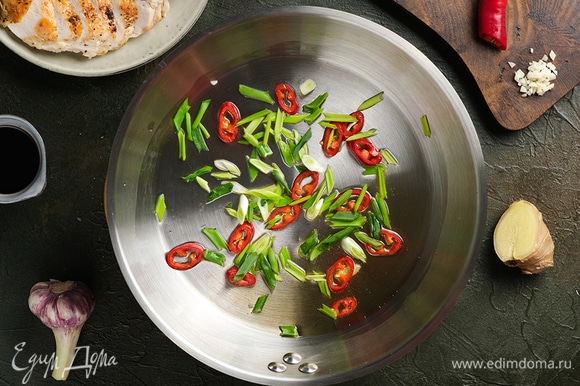 В глубокой сковороде разогрейте рисовое масло Biolio и обжарьте на нем перец чили и зеленый лук.